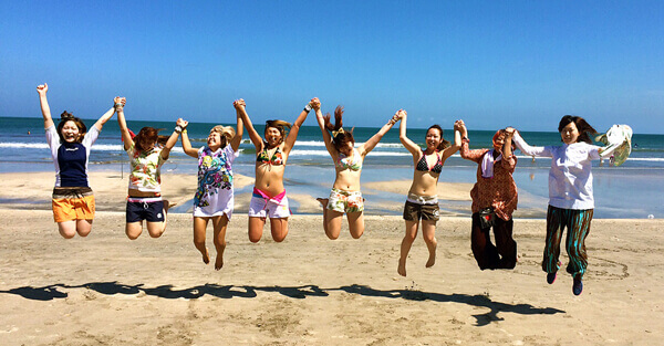 ビーチで手を繋いでジャンプする女の子たち