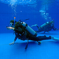 プールで中性浮力の練習をしているダイバー