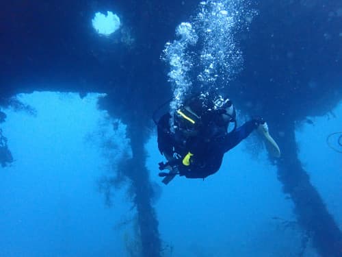 バリ島トランベンの沈船の貨物室をダイビングするゲスト