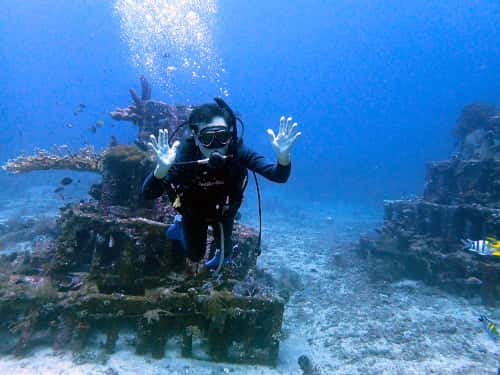 ピラミッド漁礁をバックに記念撮影するダイバー