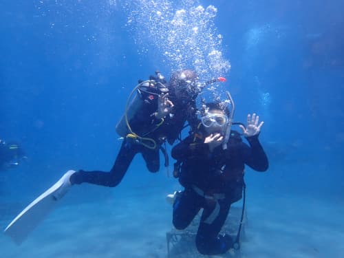 水中でインストラクターと一緒に写真を撮る体験ダイバー