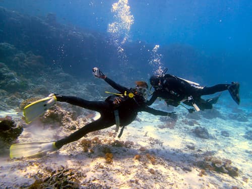 水中で記念撮影する女子学生ダイバー2名