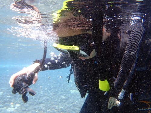 水面でレギュレータクリアの練習をする体験ダイバー