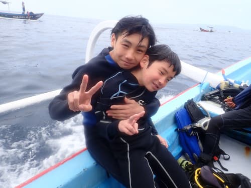 ボートの上で仲良く記念撮影する高校生と小学生の兄弟