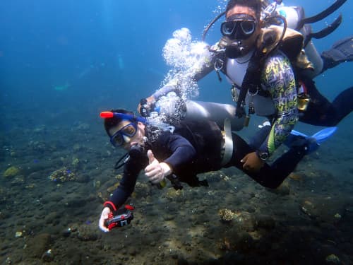 バリ島体験ダイビングのガイドとカメラに向かってポーズするダイバー