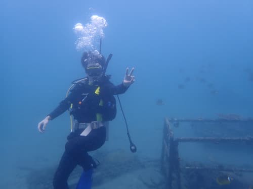 海中でピースサインをしているダイバー