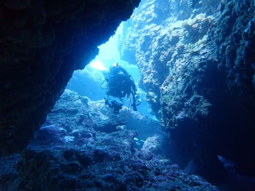 海中の洞窟を潜るダイバーの海景