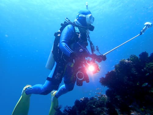 最新型水中スクーターを両足に装備、360度カメラと光量抜群のライト＆リングライトをつけた最新水中カメラを装備した、ゴテゴテダイバー