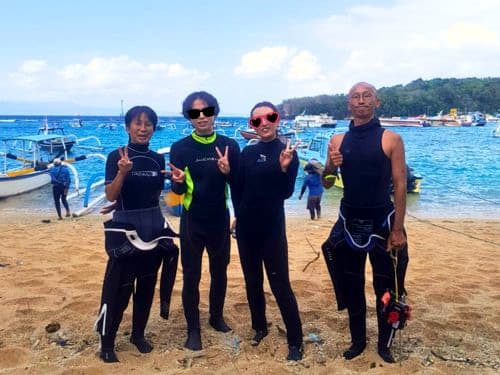パダンバイのビーチで記念撮影する体験ダイビングのゲスト様とバリ島くらげ村のインストラクターのカズとカナ