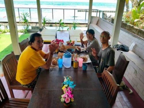 バリ島の海の見えるオープンエアのダイビングショップでローカル飯を堪能するダイビングインストラクターたち