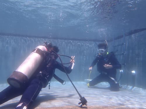 バリ島くらげ村インストラクターカナとOWダイバーコース プール実習でスキル練習をする男子学生ダイバー
