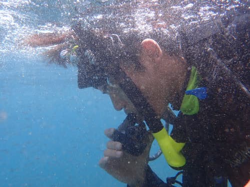 水面でマスクなし呼吸を練習する学生ダイバー