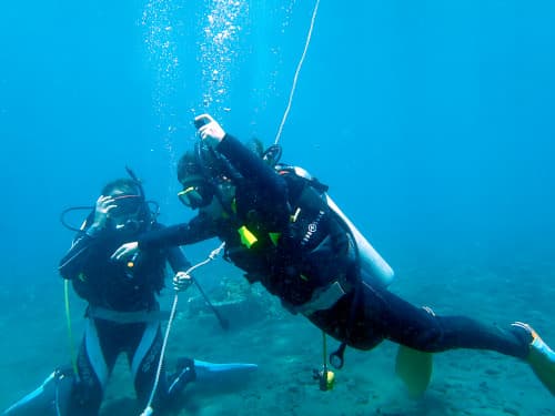 バリ島くらげ村のSSI OWダイバーコースの水中スキル「中性浮力」を頑張る女子大生ダイバーとそれを見守る女子大生ダイバー