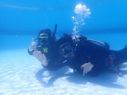 プールの水底で記念撮影する父と息子