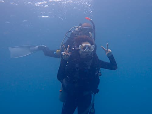 バリ島パダンバイの体験ダイビングを安全にご案内するインストラクターとピースして体験ダイビングをめちゃめちゃ楽しむダイバー