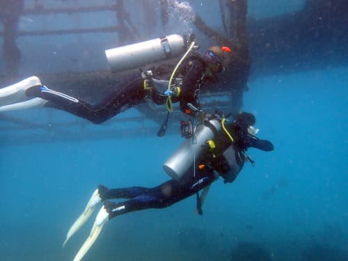 バリ島パダンバイの体験ダイビングを安全にご案内するインストラクターとのんびりと海景を眺めるダイバー
