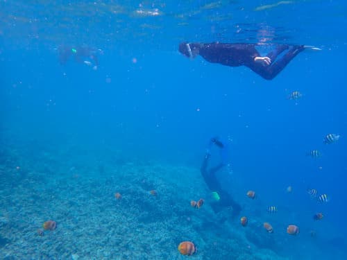 親子三人でバリ島のシュノーケリングを楽しんでいる海景