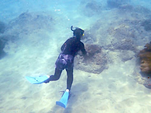 バリ島パダンバイのシュノーケリングを安全に潜りながら楽しむ女性シュノーケラー