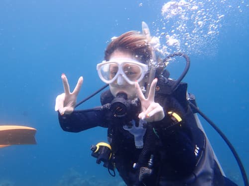怖かった海をバリ島くらげ村の“スローダイブ”で克服してダイビングを楽しむダブルピースの女性ダイバー