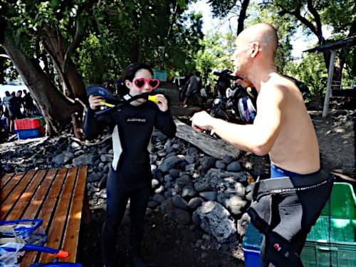 バリ島トランベンのビーチで日本人インストラクターから丁寧な体験ダイビングの説明を受けるゲスト