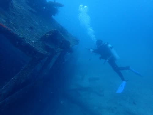 バリ島パダンバイのタンジュンジュプンの沈船を撮影するダイバー