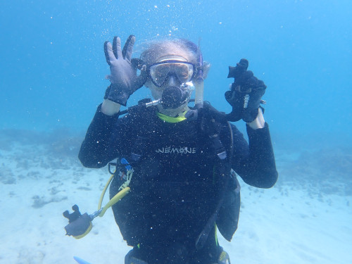 バリ島の海で水中からOKサインを見せるシニアダイバー