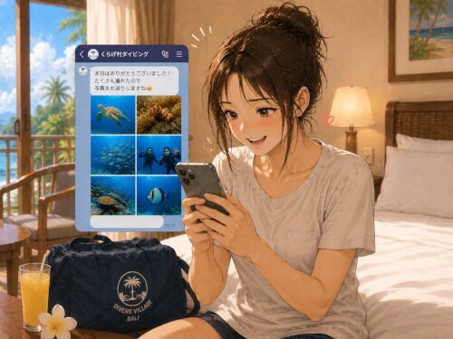 ホテルの部屋でダイビングツアー後にLINEで送られてきた水中写真を見て喜ぶ女性