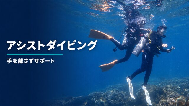 バリ島の海でインストラクターに支えられて潜るダイバー